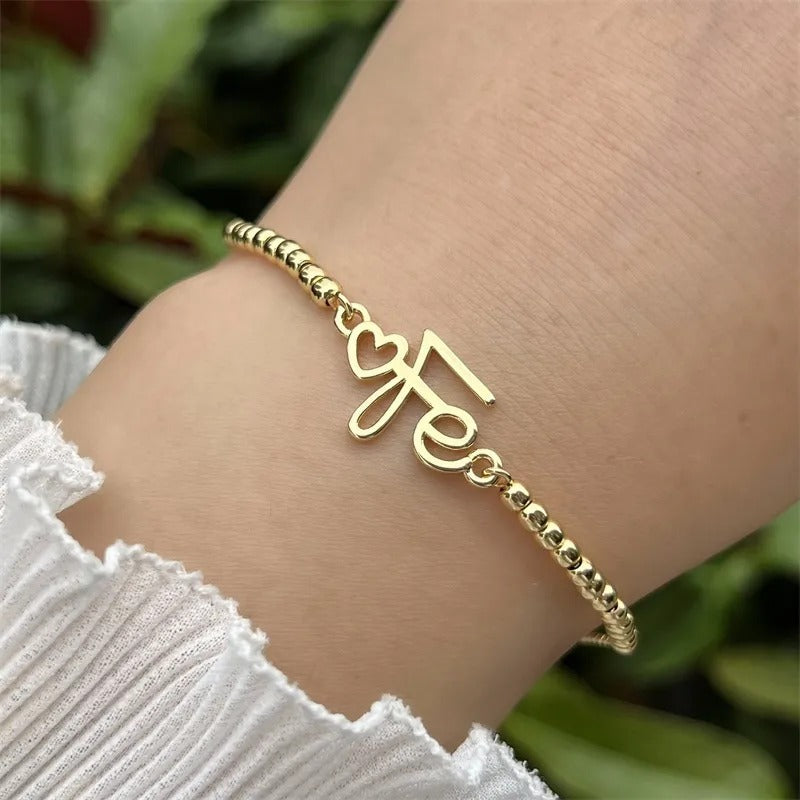 Pulsera Palabra Cursiva Fe en Tono Dorado